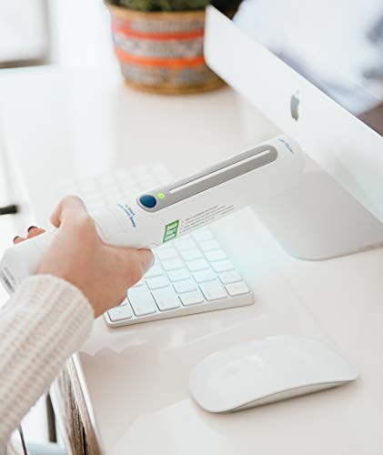 Person using a UV sanitizer on a computer keyboard