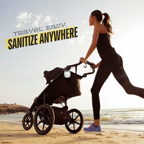 Woman jogging on beach with stroller and sanitizer.